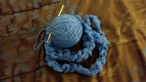 Yarn, crochet hook and work in progress