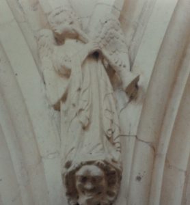 Carving of angel playing a shawm in Beverley Minster central nave. 